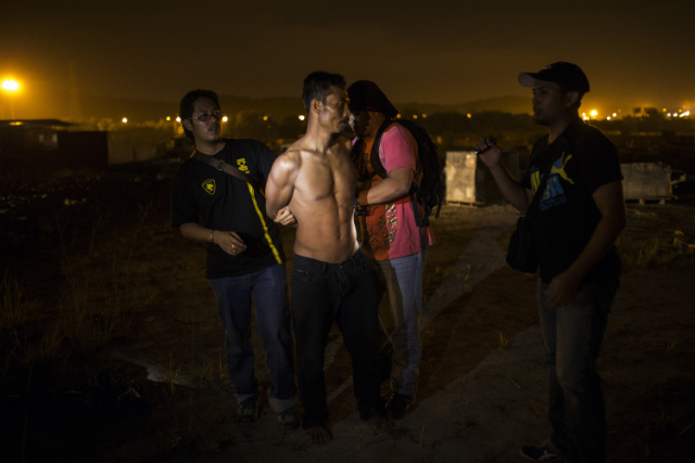 MALAYSIA'S CRACKDOWN. Suspected illegal foreign workers are arrested by Malaysian law enforcement officers during a raid in Klang outside Kuala Lumpur, Malaysia on Sept 1, 2013. File photo by Ahmad Yusni/EPA