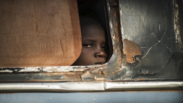 CHECKPOINT. A Malian girl looks out from a bus as Malian army soldiers prepare to check the vehicle and passengers at a checkpoint in the city of Niono, on Jan 18, 2013. AFP photo