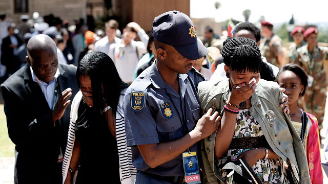 ALMOST THE END. Women are consoled as they react in sadness after walking past the casket of late South African President Nelson Mandela, on the final day of lying in state at the Union Buildings in Pretoria, South Africa. Photo by Matt Dunham/EPA