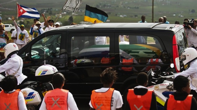 COMING HOME. People cheer as the hearse carrying the coffin of South African former president Nelson Mandela passes by on December 14, 2013 on his way to his homeland in Qunu where he will be buried. AFP / Gianluigi Guercia