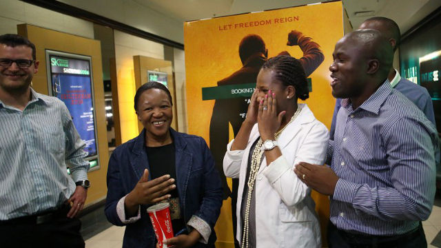 SILVER SCREEN. A group of people react as they are interviewed after seeing the film "Mandela: Long Walk To Freedom" in Johannesburg on November 28, 2013. ALEXANDER JOE/AFP PHOTO