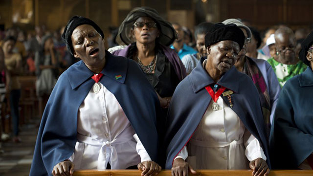 PRAYERS FOR "MADIBA". Women sing during a mass commemorating late South African former president Nelson Mandela on December 8, 2013 in Soweto, near Johannesburg. Photo by Pedro Ugarte / AFP