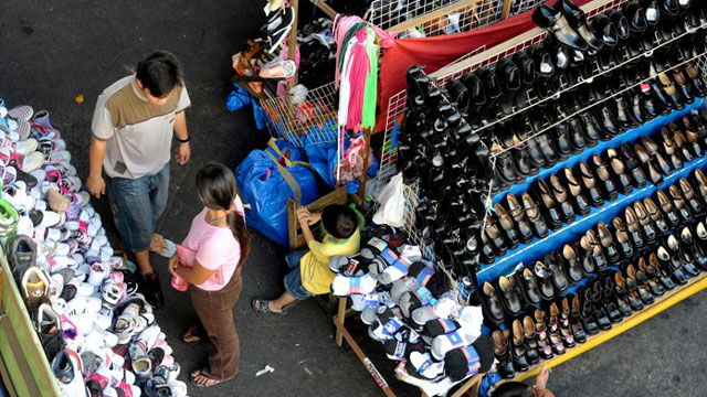 PHILIPPINES, Manila : Vendors sell cheap shoes at a market under the elevated railway in Manila on March 15, 2010. AFP PHOTO / JAY DIRECTO