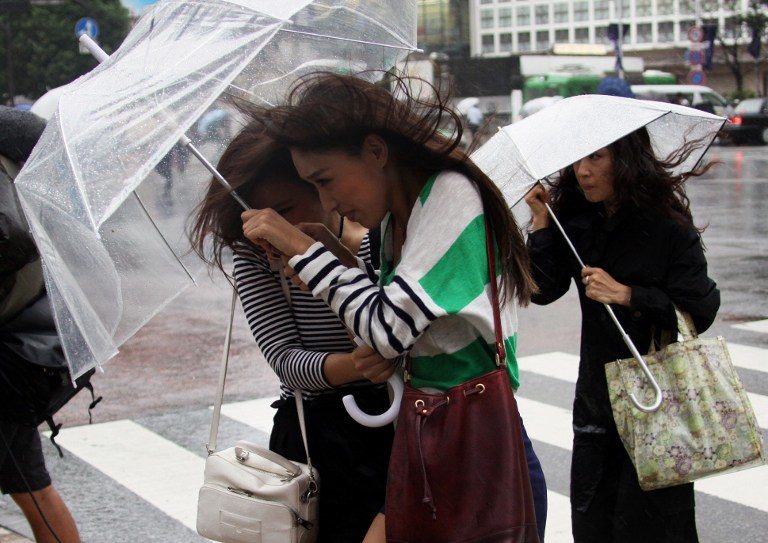 MAN-YI ARRIVES. Pedestrians walk against strong wind and rain in Tokyo on September 16, 2013. AFP / Yoshikazu Tsuno