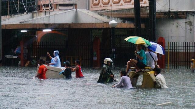 WAIST HIGH. People brave floodwater at Vito Cruz, which is not passable as of 8am Tuesday, August 20. Photo by John Allanegui