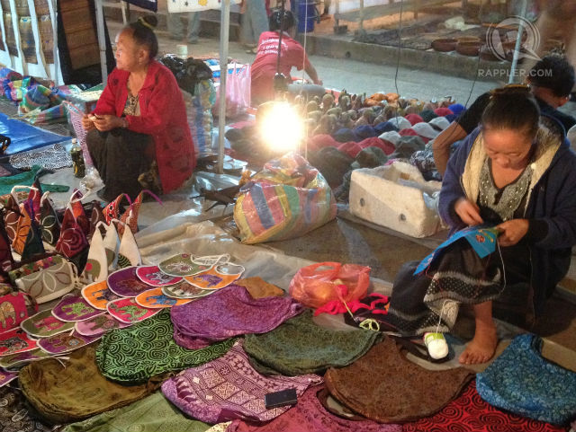 NIGHT MARKET. Hmong and other tribal people set up a nightly market to sell traditional and contemporary textiles and other souvenirs in Luang Prabang