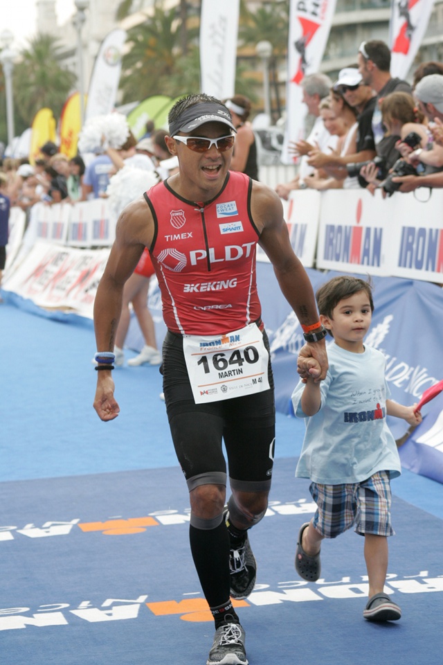 FINISHING STRONG. Martin Lorenzo holds his son Matteo's hand as he crosses the finish line of the Ironman race. Photo from Martin Lorenzo.