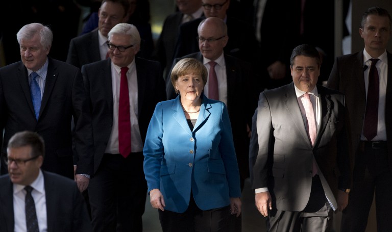 BACK IN POWER. German Chancellor Angela Merkel (center), along with other top German officials,  arrives for the signing of the new "grand coalition" government agreement at the German Parliament on December 16, 2013. AFP/John Macdougall