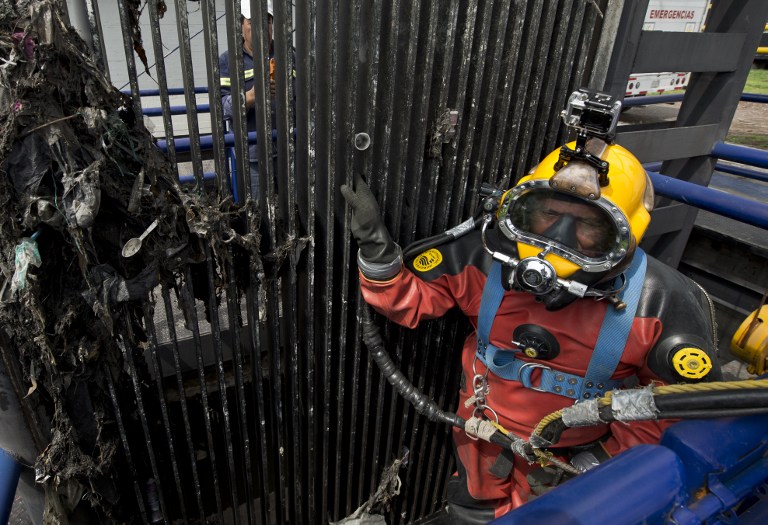 PREPARING TO DIVE. Mexican diver Julio Cesar Cu prepares to be lowered into the sewage to begin the process of clearing the floodgates of garbage on August 21, 2013, at one of the pumping plants of Mexico City's sewage system. AFP/Ronaldo Schemidt