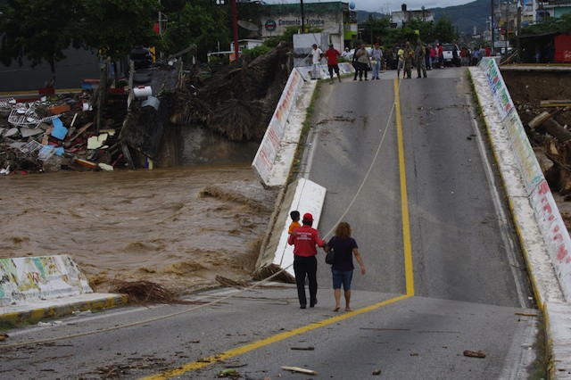 CUT OFF. Inhabitants cross a collapsed bridge assisted by members of the Mexican Army in Cocuya de Benítez, Guerrero state, Mexico, 18 September 2013. EPA/Francisca Meza