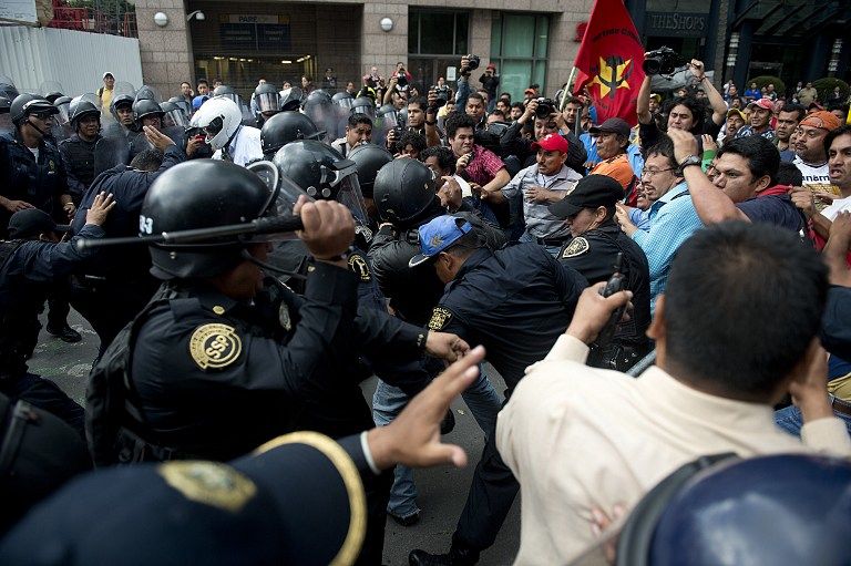 RALLY VIOLENCE. Riot policemen clash with teachers during a protest against the educational reform proposed by President Enrique Pena Nieto, along Reforma avenue in Mexico City on September 11, 2013. AFP/ Yuri Cortez