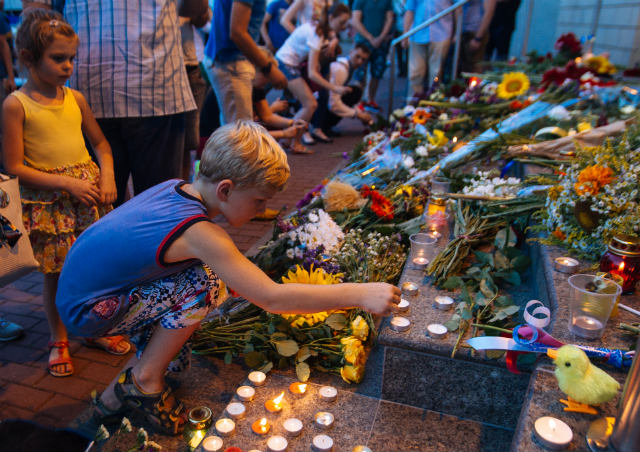 DAY OF MOURNING. A young boy lights a candle in commemoration of the victims of Malaysia Airlines plane accident in eastern Ukraine in front of the Dutch embassy in Kiev, Ukraine on July 17, 2014. Photo by Roman Pilipey/EPA