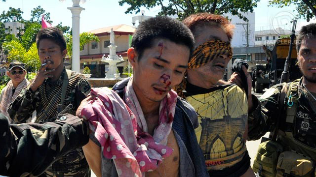 SUSPECT OR HOSTAGE? Men allegedly part of the MNLF group being taken into custody by the military in Sta Catalina, Zamboanga City, September 14, 2013. They insist, however, they are among the civilian hostages. Photo by LeAnne Jazul/Rappler