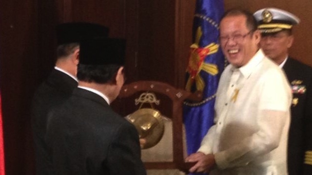 In this photo tweeted by Deputy Presidential Spokesperson Abigail Valte, President Benigno Aquino III (R) smiles as he receives the Gong for Peace from Moro Islamic Liberation Front (MILF) chief Murad Ebrahim (L, partly hidden) during their meeting at Malacañang Palace, October 15, 2012.