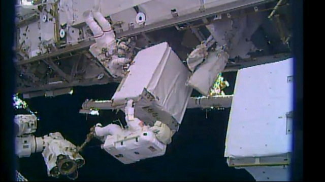 WORK DONE. This Dec 24, 2013 NASA TV still image shows astronaut Mike Hopkins (L) on the robotic arm holding a spare pump and Rick Mastracchio position a spare pump as they slide it into the truss during a spacewalk outside the International Space Station (ISS). AFP photo