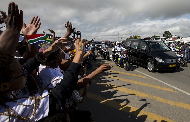 HOME. Thousands of people lining the streets cheer as the hearse carrying the body of Nelson Mandela drives from Mthatha to Qunu, South Africa, December 14. Photo by Ian Langsdon/EPA