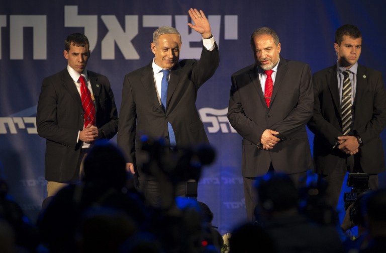 In this file photo, flanked by bodyguards, Israeli Prime Minister Benjamin Netanyahu (C-L) and ultra-nationalist Avigdor Lieberman (C-R) of the Likud-Beitenu coalition party greet supporters as they arrive on stage on elections night on January 22, 2013 at the party's headquarters in Tel Aviv. AFP PHOTO / JACK GUEZ
