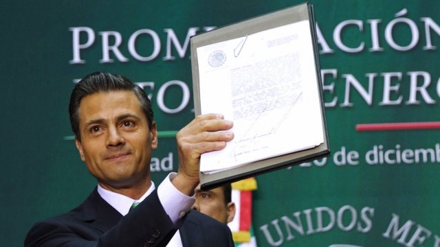 OIL INDUSTRY OPEN. Mexican President Enrique Pena Nieto holds up the signed decree to promulgate the energy reform, during a ceremony at the National Palace in Mexico City, on December 20, 2013. AFP / Presidencia