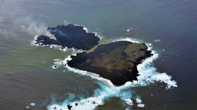 MERGING ISLANDS. A new islet forming due to volcanic eruptions (L) is shown beside Nishino-shima island, part of Japan's Ogasawara island chain, on 25 December 2013. Image courtesy of Japan Coast Guard