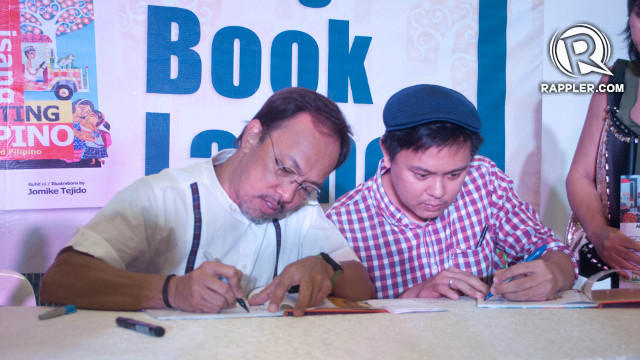 MEET THE AUTHOR. Noel Cabangon (left) and illustrator Jomike Tejido (right) sign copies of their book for children. Photo by Celline Alias