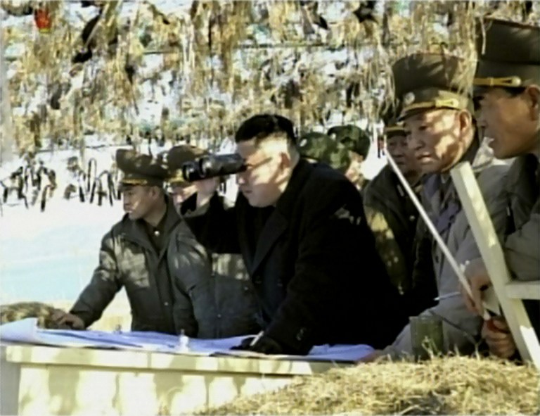 LOOKING FOR WAR? This screen grab taken from North Korean TV on March 12, 2012 shows North Korean leader Kim Jong-Un (C) looking through binoculars towards a South Korean island during a trip to an artillery unit on Wolnae Island near the disputed maritime frontier with South Korea. AFP PHOTO / NORTH KOREAN TV