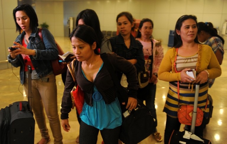 BACK HOME. Some of the 30 repatriated Filipino workers arrive at the Manila International Airport on Nov 4, 2013. Photo by AFP/Jay Directo