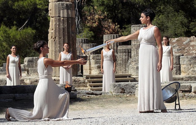 OLYMPIC FLAME. Actress Ino Menegaki (front R), in the role of the High Priestess, lights the torch of the Olympic Flame during the rehearsal of the Lighting Ceremony of the Olympic Flame for the Sochi Winter Olympics 2014, in front of the Hera Temple in Ancient Olympia, Greece, 28 September 2013. EPA/Orestis Panagiotou