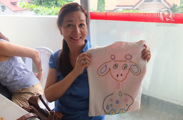 SATISFIED CUSTOMER. A bazaar-goer proudly shows her purchase, handcrafted shopping bags by the school's students