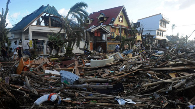 STRUGGLE FOR NORMALCY. People walk among debris and destroyed houses in Palo, eastern island of Leyte on November 10, 2013, three days after devastating Super Typhoon Haiyan hit the area on November 8. Photo by Agence France-Presse