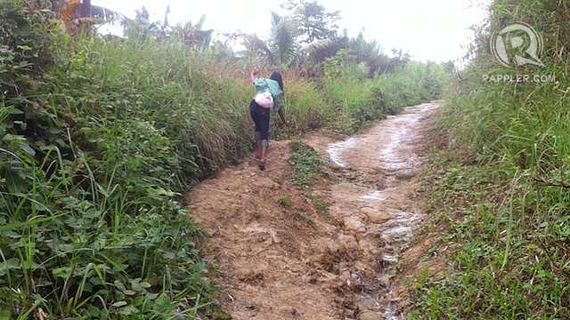 UNFINISHED ROAD. A lady tries to maintain her balance as she walks along an uneven road to a remote coastal barangay in Catbalogan, Samar. Photo by Judith Balea