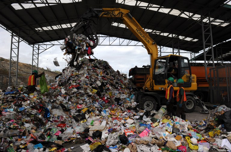 ALTERNATE FUEL. In this photo taken on February 21, 2013, workers segregating garbage at the Material Recovery Facility (MRF) in Payatas landfill, Quezon City suburban Manila. The sorted recyclable materials are sifted by machine shredder which are then compacted, and wrapped with plastic and convert them into bales, where they are bought by companies to be used as alternative burning fuel. AFP/Ted Aljibe