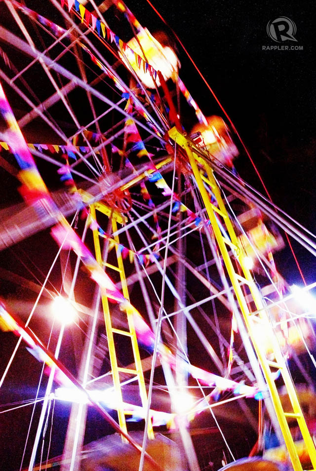 SPINNING WHEEL. The ferris wheel, or chubibo, with banderitas twined around its spokes