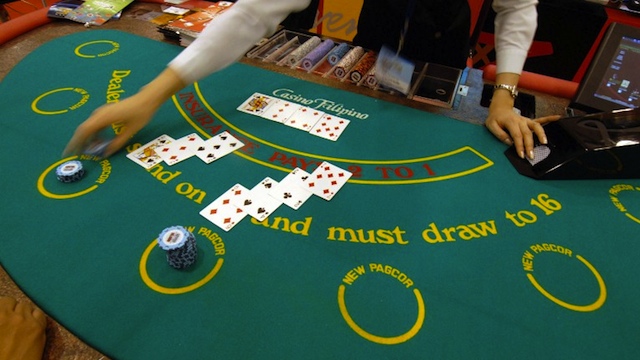 GAMBLING PARADISE. A dealer plays card with visitors during a two-day exhibit on the gaming industry in Manila, 22 March 2007. AFP PHOTO/ROMEO GACAD