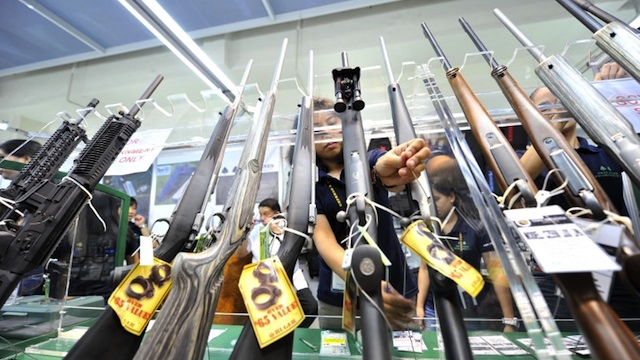 GUNS IN PH. This photo taken on July 15, 2010 shows shop assistants arranging rifles for sale at a gun show in Manila. AFP PHOTO/TED ALJIBE