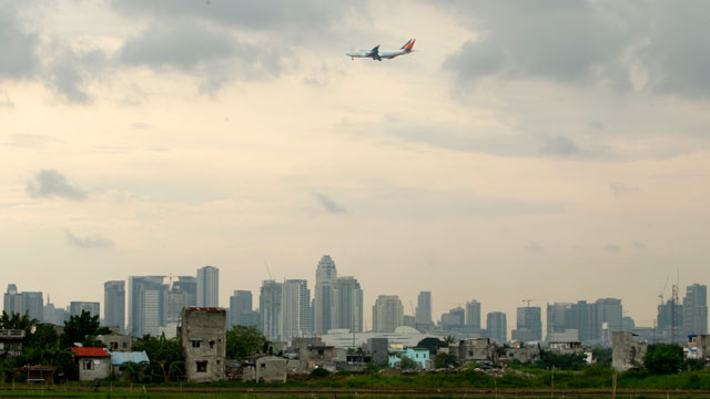 An airplane flies over Manila's skyline on heavy clouds in Taguig city, south of Manila, July 16. Photo by EPA/Francis R. Malasig