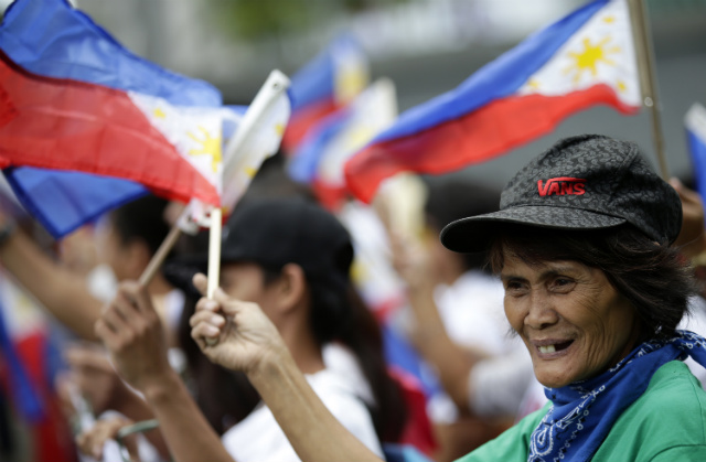 BOTH CLAIMANT-COUNTRIES. Filipinos wave Philippine flags as they join Vietnamese nationals in a commemoration of the Vietnam-China border war in 1979, in front of the Chinese consulate in Makati on Feb 17, 2014. Protesters aim to support Manila in an ongoing stand-off with China. File photo by Dennis Sabangan/EPA