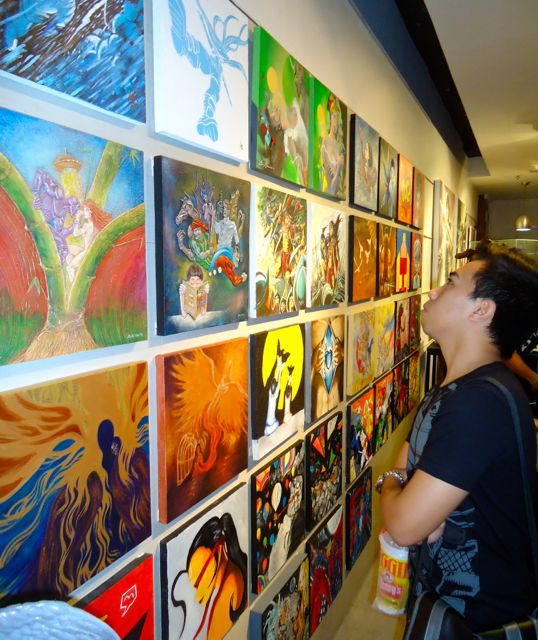 ART APPRECIATION. A comic book fan marvels at the Pinoy comics-inspired artwork
