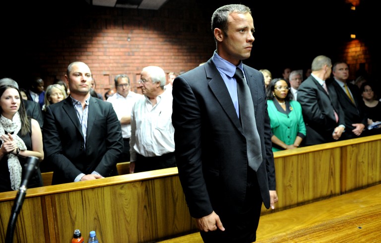 South African Olympic sprinter Oscar Pistorius (C) appears on February 19, 2013 at the Magistrate Court in Pretoria as he father Henke (3rd L), brother Carl (2nd L) and sister Aimee (L) attend. AFP PHOTO / STEPHANE DE SAKUTIN