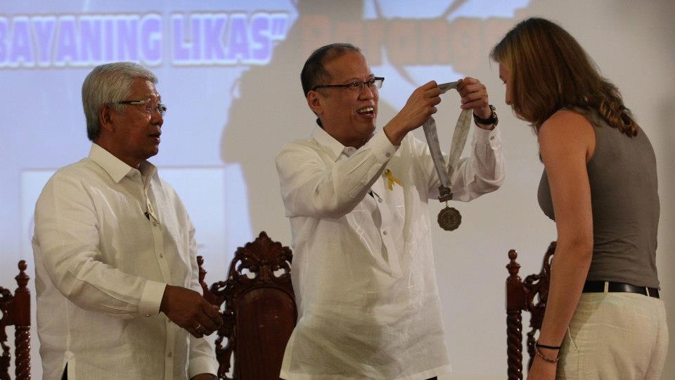 President Aquino and Defense Secretary Voltaire Gazmin present the Bakas ng Parangal ng Kagitingan bronze medallion to Malapascua American volunteer technical diver Shelagh Cooley. Cooley was among three volunteer technical divers from Cebu who helped in the search operations for Robredo. Photo by Malacañang Photo Bureau  