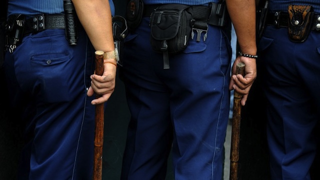 CHEATING COPS? Policemen hold their truncheons during a protest near the US embassy in Manila on March 20, 2012. AFP PHOTO/NOEL CELIS