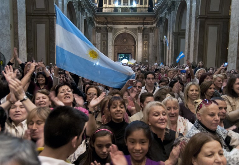Argentine faithful celebrate at the cathedral in Buenos Aires on March 13, 2013, after knowing that Argentina's cardinal Jorge Mario Bergoglio was elected Pope, to replace the frail Benedict XVI as leader of the world's 1.2 billon Catholics. AFP PHOTO / NA - MARIANO SANCHEZ