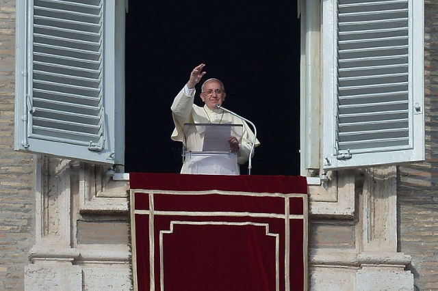 NEW YEAR. Pope Francis greets the crowd from the window of the apostolic palace overlooking St.Peter's square during his Sunday Angelus prayer on January 1st, 2014 at the Vatican. Filippo Monteforte/AFP Photo