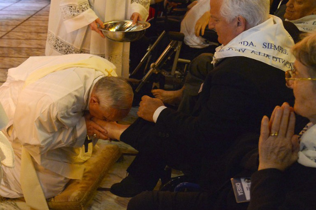 SYMBOL OF SERVICE. Pope Francis (L) kisses the foot of a man as he performs the traditional 'Washing of the Feet' during a visit at a center for disabled people as part of Holy Week on April 17, 2014 in Rome. Photo by Alberto Pizzoli/AFP
