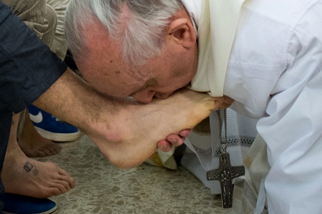 SYMBOL OF SERVICE. This handout picture released by the Vatican press office shows Pope Francis (R) kissing the feet of a young offender after washing them during a Mass at the church of the Casal del Marmo youth prison on the outskirts of Rome as part of Holy Thursday. Photo by AFP/Osservatore Romano 