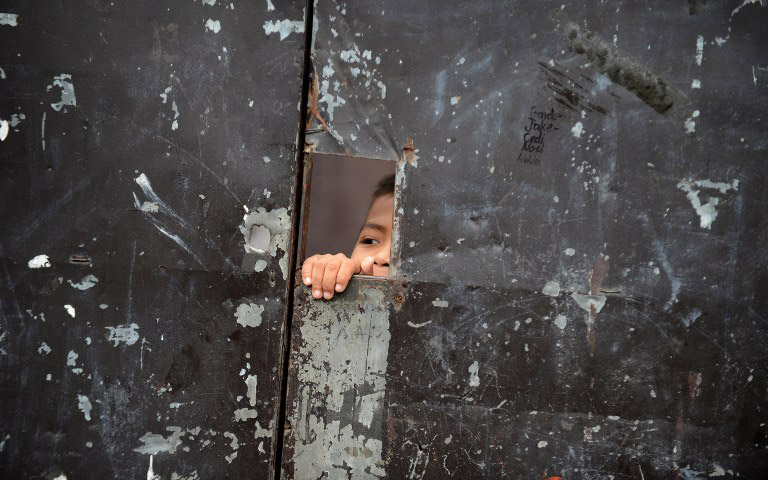 PEEK-A-BOO. Latest survey shows poverty and hunger rise as 2013 ends. Photo by Noel Celis/AFP