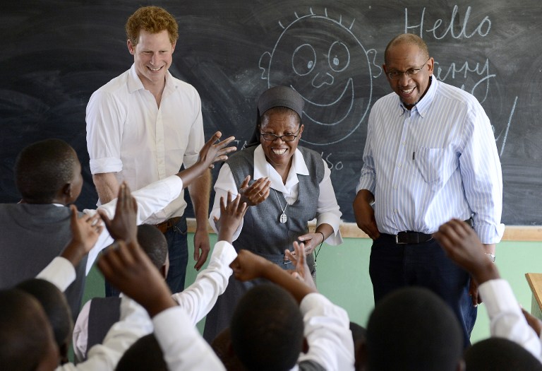 Britain's Prince Harry (L) flanked by Sister Victoria Mota (C) and Prince Seeiso, the younger brother of King Letsie of Lesotho, interacts with pupils at the Kananelo Centre for the Deaf on February 27, 2013 in Maseru. AFP PHOTO / STEPHANE DE SAKUTIN