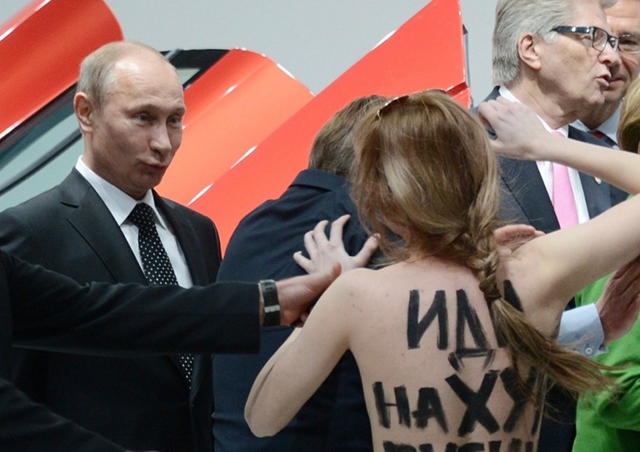PUTIN’S JOKE. A topless demonstrator walks towards Russian President Vladimir Putin during his visit to an industrial fair in Hanover, Germany. She and fellow protesters shouted “fuck dictator” but Putin joked that he “liked” the protest. AFP/ Jochen Lübke