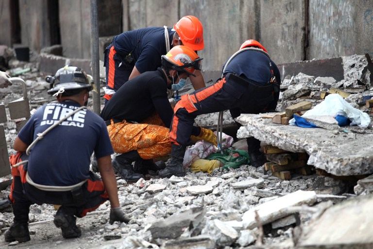 CASUALTY. Rescuers try to uncover an unidentified man under slabs of cement in Cebu City, Philippines after a major 7.1 magnitude earthquake struck the region on October 15, 2013. AFP / Chester Baldicanto