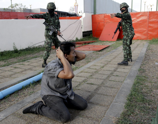 COUP DECLARED. A Thai Red Shirt pro-government supporter is arrested by soldiers after the army declared a coup at the rally site on the outskirts of Bangkok, Thailand on May 22, 2014. Photo by EPA