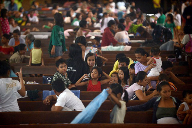 HUNDREDS OF THOUSANDS. Like over 360,000 others, victims evacuate to a church in Manila on August 20. Photo by AFP/Noel Celis